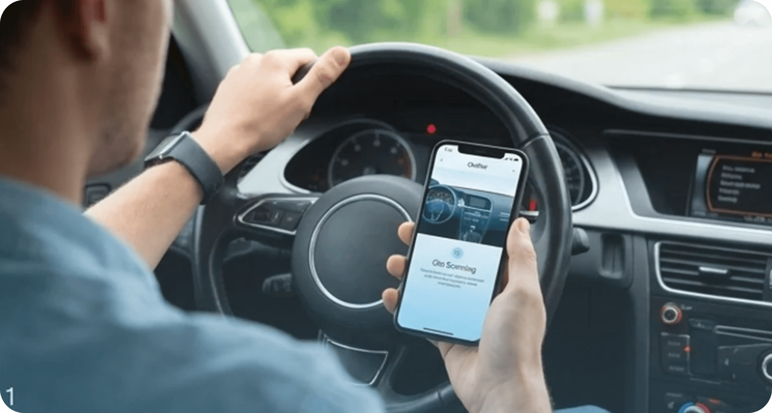 A driver holding a phone running Oto while parked